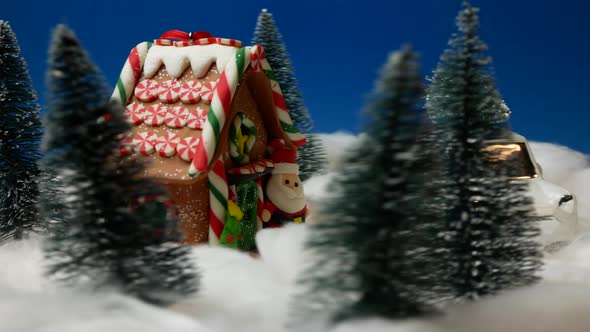 Christmas and New Year decoration. Amazing winter scene with toy Santa Claus and gingerbread house