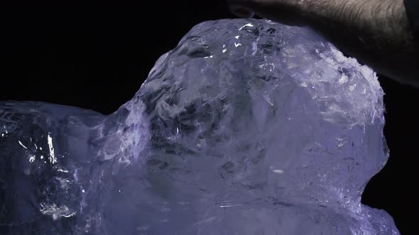 Artist is Shaping a Big Block of Ice to Create an Ice Sculpture Using a Knife