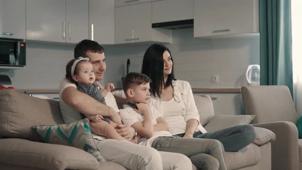 Happy Family Watching Tv at Home on Couch