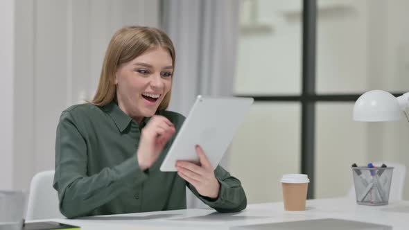 Successful Woman Celebrating on Tablet at Work