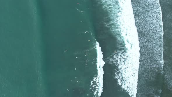 Top down of waves break on tropical sea Surfers with surfing boards