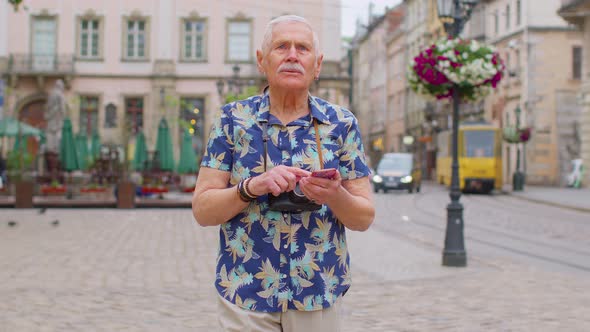 Senior Traveler Man Grandfather Pensioner Getting Lost in City Trying to Find Route on Mobile Phone