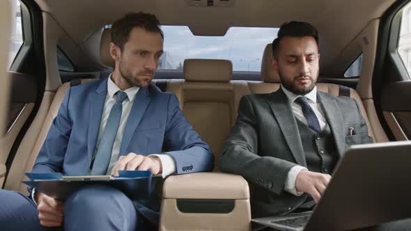Diverse Businessmen Working in Car