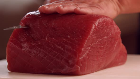 Hands with Knife Cutting Meat.