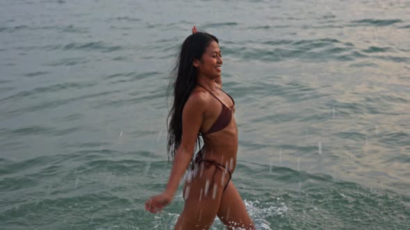 Woman Walking And Splashing In Sea