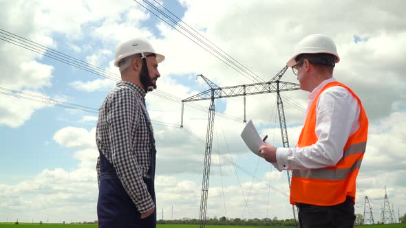 Two Engineers Working Near Transmission Lines