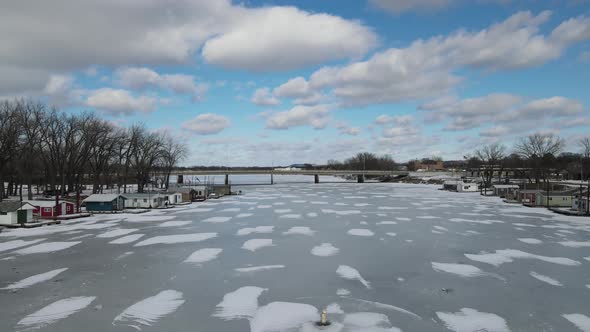 Drone view over frozen river in Wisconsin a bright sunny day.