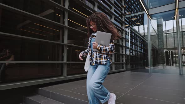 Portrait of Beautiful African American Woman with Curly Hair Wearing the Shirt and Jeans Hurries Up