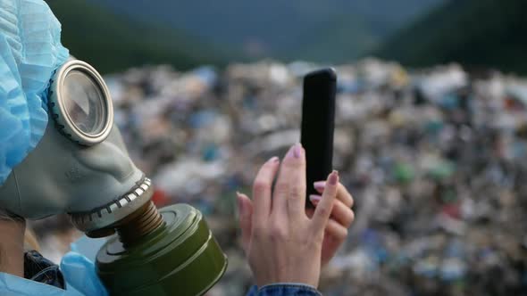 Woman wearing a gas mask on a landfill, a lot of garbage, an ecological catastrophe