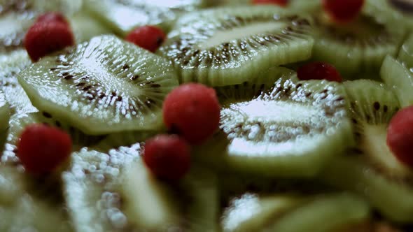 Juicy Fresh Kiwi Slices and Frozen Red Currant Arranged in a Shape of Christmas Tree on a Black