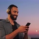 Young Bearded Multinational Man chilling while listening to Music in Headphones. - VideoHive Item for Sale