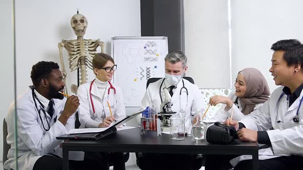 Male and Female Future Medical Workers Carefully Listening the Respected Bearded Doctor-Mentor