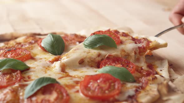 Camera follows a hand picking up a slice of pizza. Slow Motion. alt