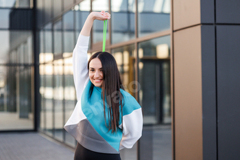 Fitness woman working with fitness rubber band outdoors. Fit girl training with rubber expander