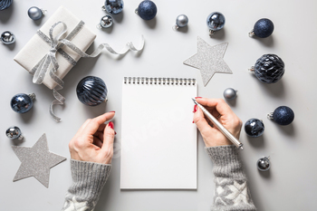 Woman writes goals, checklist, plans and dreams for New Year.