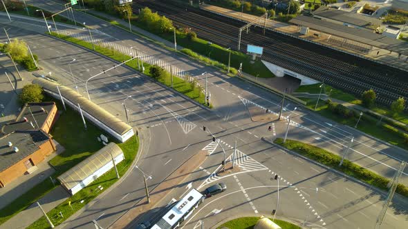 Articulated Bus With Cars Stopped At An Intersection And Wait For The Light Signal To Turn Green At