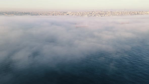 drone flying above sea with city view in foggy day