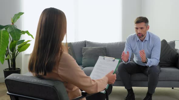 Upset Emotional Man Patient with Mental Health Problems Talking to Therapist