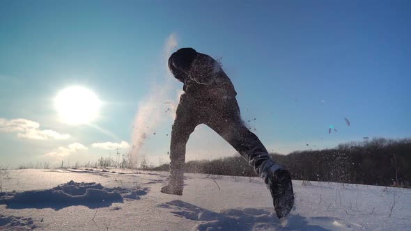 Happy Guy Runs in the Snow Against the Backdrop of the Beautiful Sun and Sky