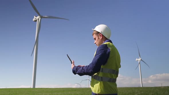 Specialist Standing Near Wind Mill Using Tablet and Making Inspe