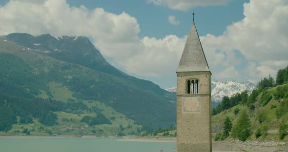 Medium Shot, Scenic view of Kirchturm von Altgraun in Italy, Reschensee and mountain range in the ba