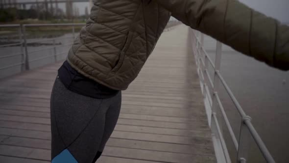 Joyful Hindu Woman Training at Seaside During Overcast Weather.