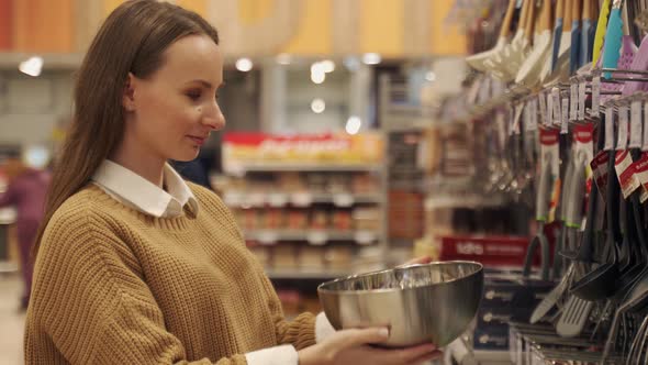 A Female Customer Choosing Dishes in a Cookware Store