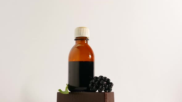 Medicine In A Jar On A Turntable On A White Background, A Bottle Of Medicine From A Black Berry.