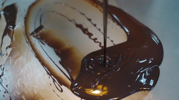 Woman Mixes Chocolate Glaze Using Metal Pastry Scraper