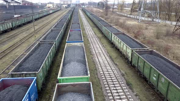 Long row of train cargo cars loaded full with fossil fuel coal.