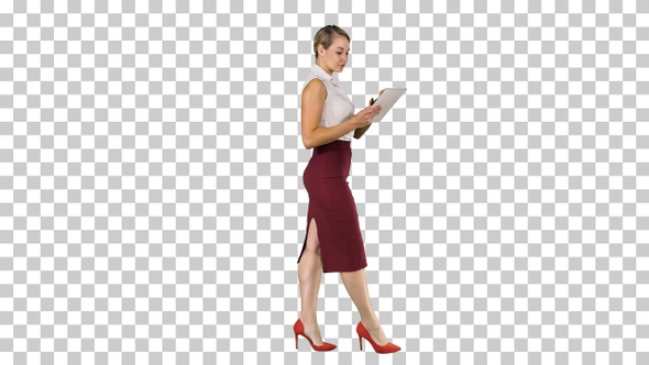 Businesswoman using electronic tab walking, Alpha Channel