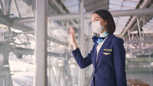 Airliner air hostess crew wearing face mask walking in airport terminal to the airplane during Covid