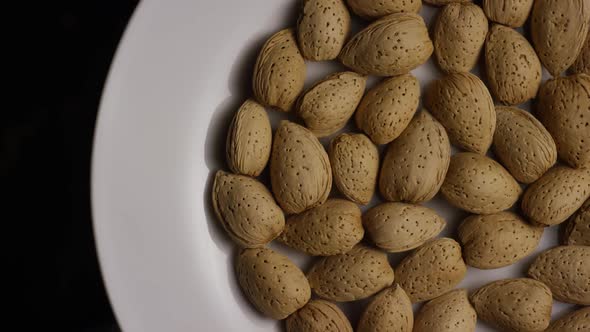 Cinematic, rotating shot of almonds on a white surface