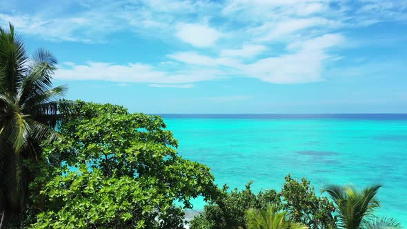 Wide angle above travel shot of a white sand paradise beach and blue water background in high resolu