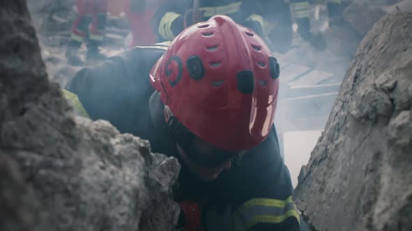 Male Rescuer Talking to Survivors Under Rubble