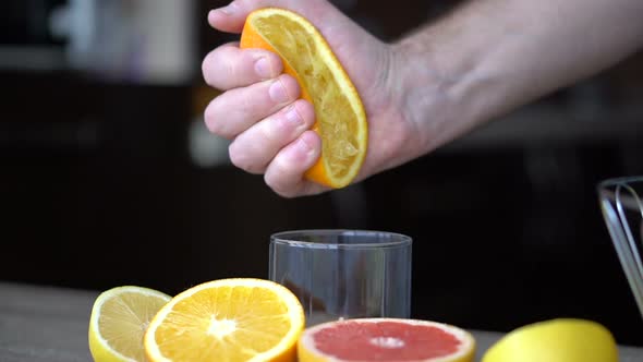 A Man Squeezes Orange Juice with Citrus Juicer