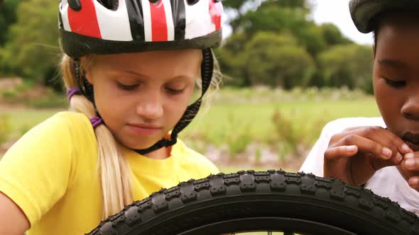 Group of kids looking at bicycle wheel