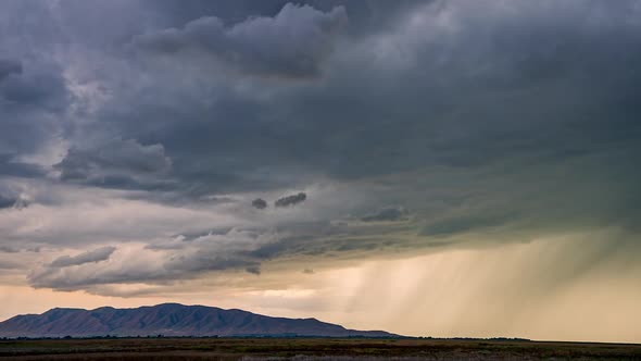 Rainstorm following dark clouds rolling through the sky in Utah Valley