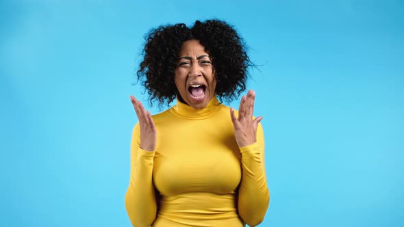 African American Furious Woman Shouting on Blue Background