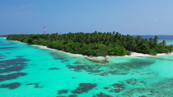 Daytime overhead travel shot of a white sandy paradise beach and aqua blue water background in 4K