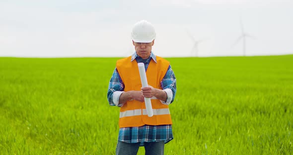 Male Engineer Working While Holding Blueprint