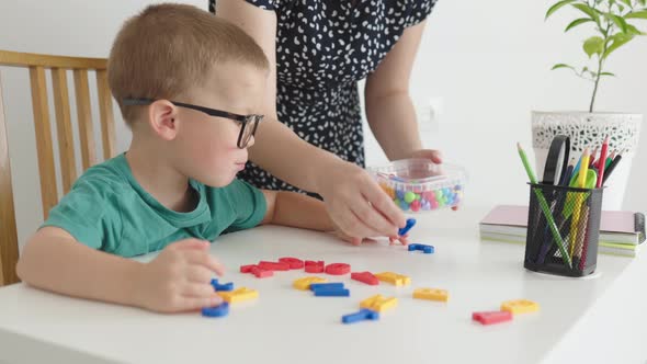 Happy Pupil Child Kid in Glasses Studying at Home Female Woman Showing Letters alt