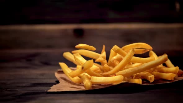 Super Slow Motion French Fries on Paper Falls on the Table and Scatters