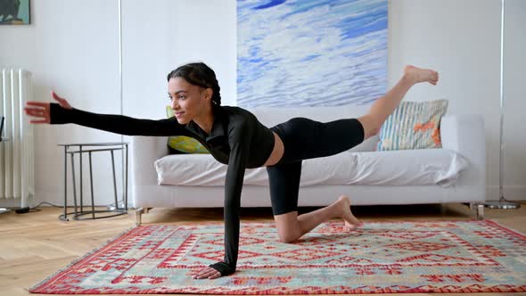 Cute Sportive African American Girl in Black Sportswear Doing Stretching on the Floor at Home Doing