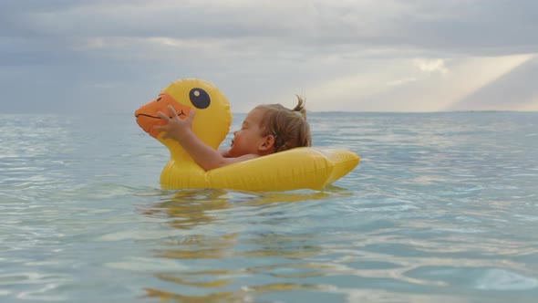 Portrait of Little Adorable Baby Floating on an Inflatable Duck in the Indian Ocean