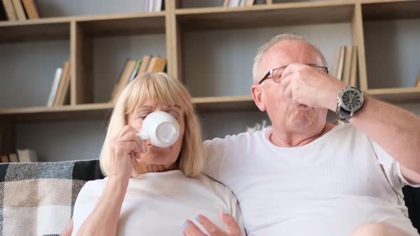 Old Man and Wife Drinking Coffee in Their Living Room