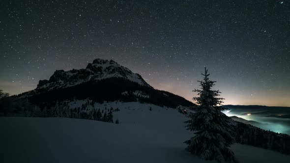 Night Sky with Stars Moving over Mountain Peak in Winter Astronomy