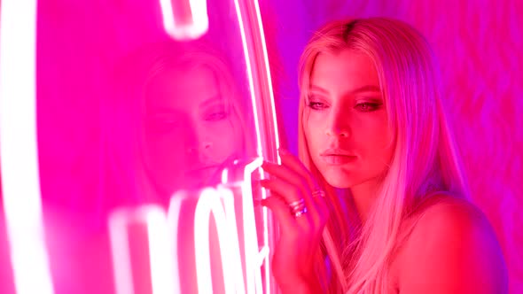 Portrait of a Cute Blonde Maid in a Pink Room in Neon Light