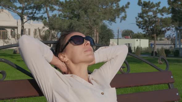 The woman relaxed in the park on the bench.