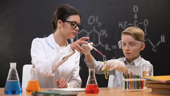 Schoolboy Dripping Red Substance in Test Tube, Chemistry Teacher Helping, Lesson